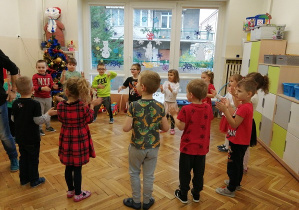 dzieci stoją w kole i klaszczą przy śpiewaniu